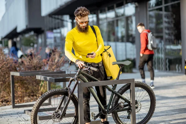 Homem entregando comida com saco térmico em uma bicicleta — Fotografia de Stock