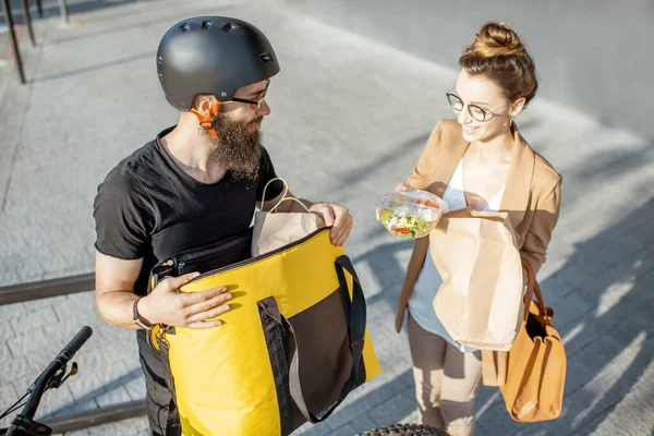 Mensajero entregando comida a una mujer de negocios — Foto de Stock