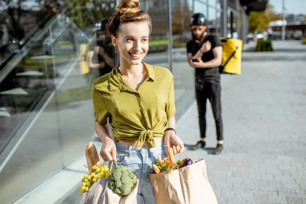 Woman with fresh products received from a courier