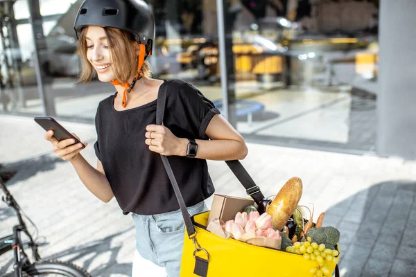 Correio feminino entregando alimentos frescos com uma mochila — Fotografia de Stock