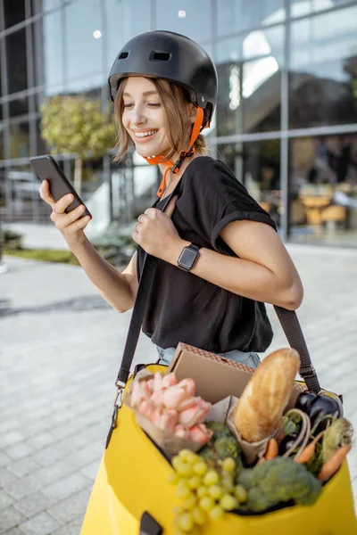 Correio feminino entregando alimentos frescos com uma mochila — Fotografia de Stock