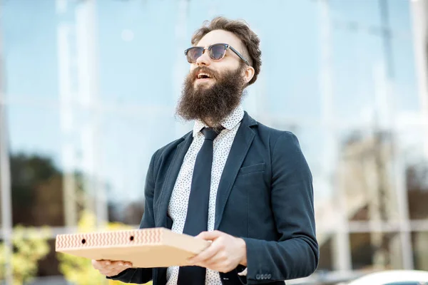 Affärsman med pizza utomhus — Stockfoto