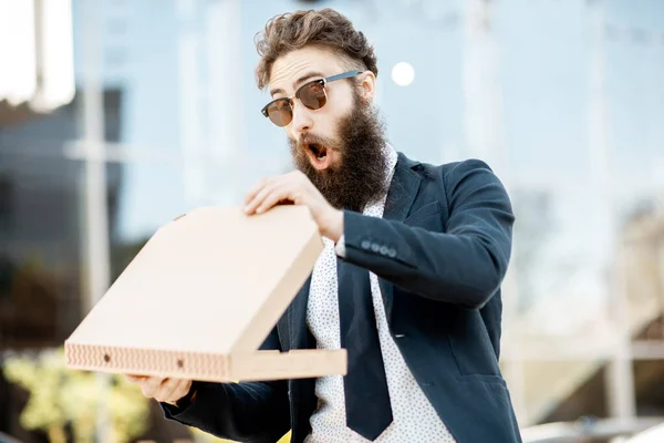 Açık havada pizza yiyen bir iş adamı. — Stok fotoğraf