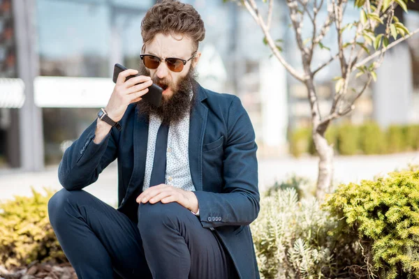 Emotional businessman talking phone outdoors — Stock Photo, Image