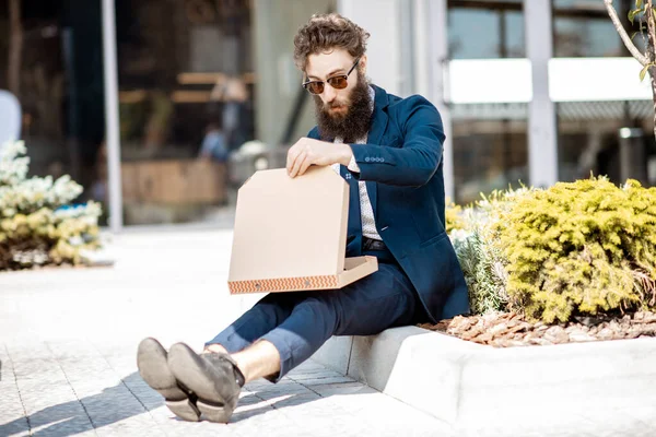Forretningsmann som spiser pizza-utløpere – stockfoto