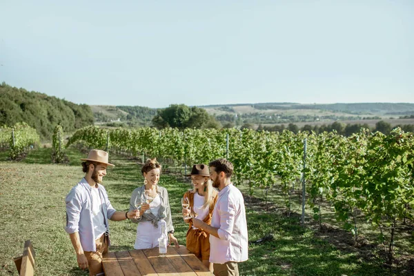 Barátok kóstolják a bort a szőlőskertben — Stock Fotó