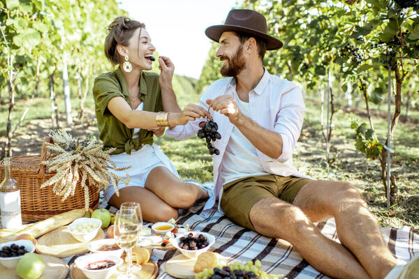 Young couple having a breakfast on the vineyard