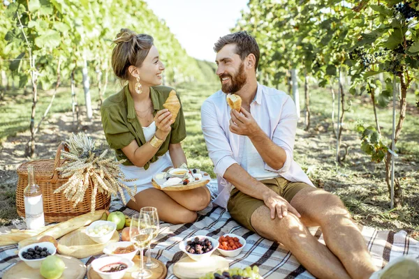 若いカップルがブドウ畑で朝食を持っている — ストック写真