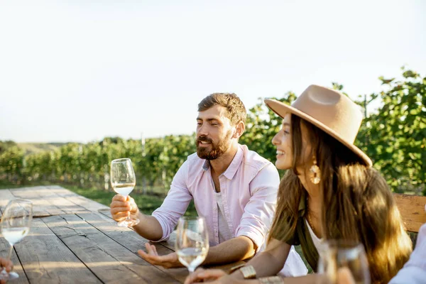 Vrienden die wijn drinken aan de eettafel op de wijngaard — Stockfoto