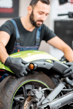 İşçi atölyede motosiklet tamir ediyor.