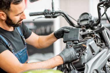 Elektrikçi motorsiklet kablolarını tamir ediyor.