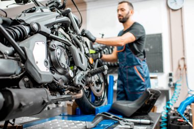 Atölyedeki işçiyle motosiklet.