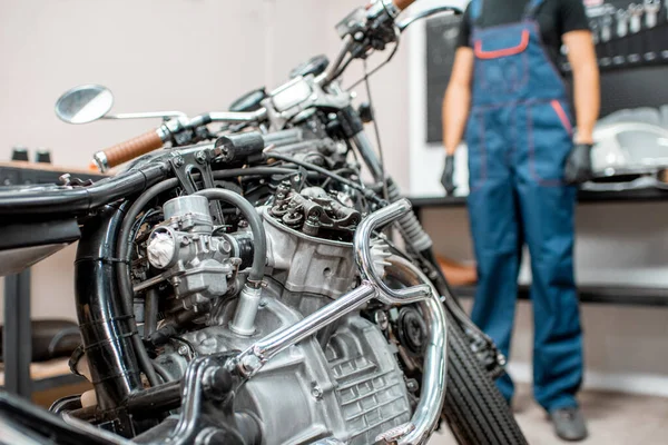 Vintage motorfiets met arbeider in de werkplaats — Stockfoto