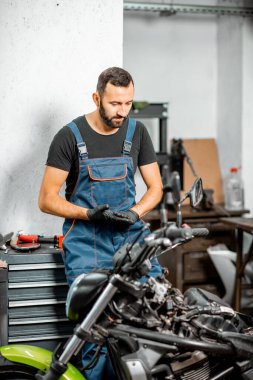 Garajında motosikletli bir motorcu.