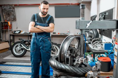 Motosiklet lastiği değiştiren bir işçi.