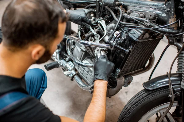 Trabajador reparando motor de motocicleta en el taller — Foto de Stock