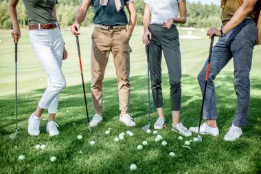 Golf sahasında ekipmanı olan insanlar.