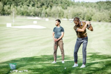 Dışarıda golf oynayan adamlar.