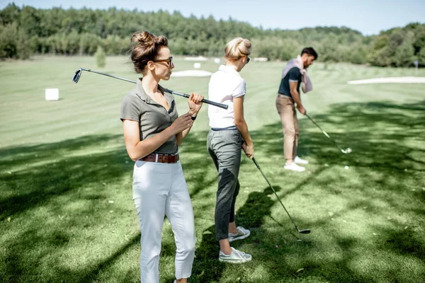 Arkadaşlarıyla golf oynayan bir kadın — Stok fotoğraf