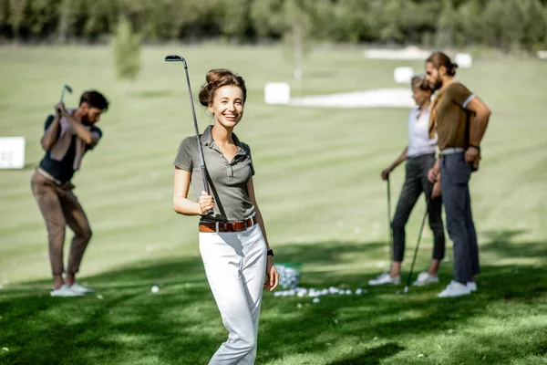 Arkadaşlarıyla golf oynayan bir kadın — Stok fotoğraf