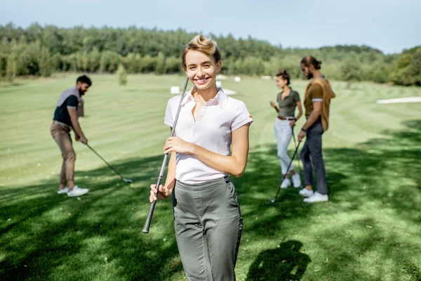 Arkadaşlarıyla golf oynayan bir kadın — Stok fotoğraf