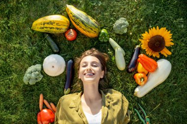 Çimlerde taze sebzeleri olan bir kadın.