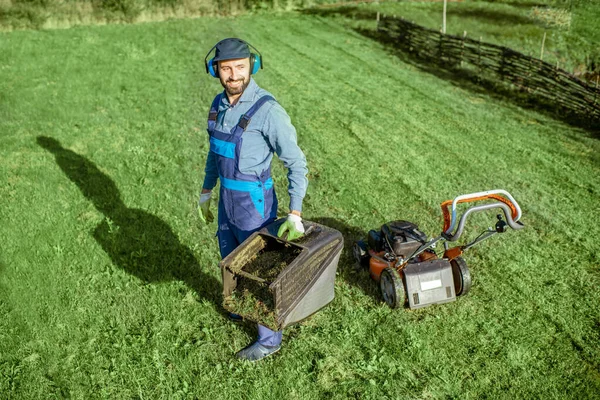 Gardener working with lawn mower on the backyard — Stock Photo, Image