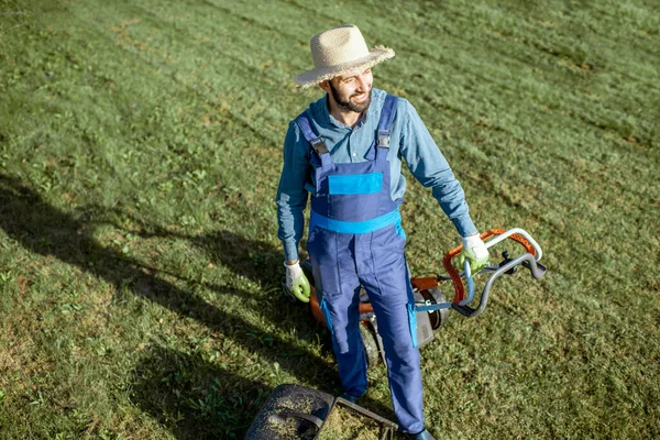 Gardener working with lawn mower on the backyard — Stock Photo, Image