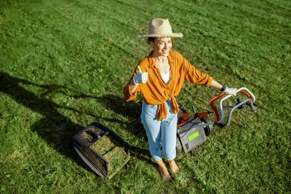 Femme avec tondeuse à gazon sur le jardin — Photo