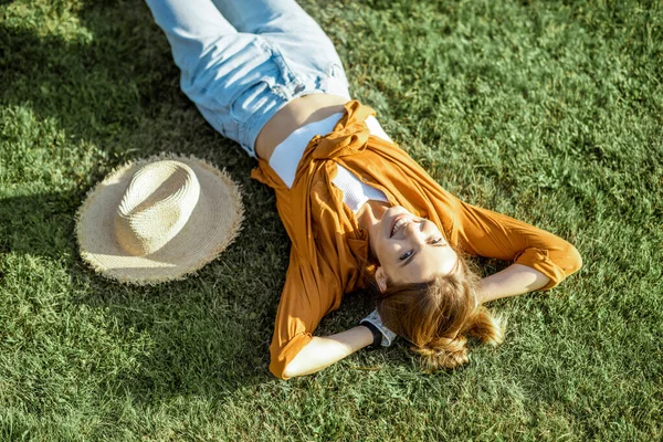 Женщина лежит на зеленой лужайке — стоковое фото