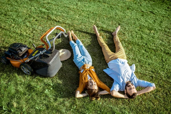 Uomo e donna con tosaerba sull'erba — Foto Stock