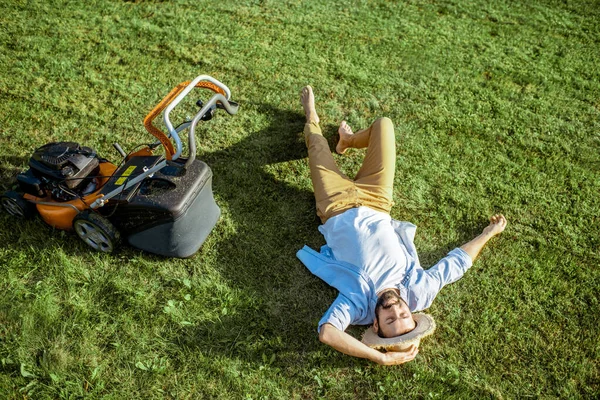 Człowiek na trawie z kosiarką — Zdjęcie stockowe