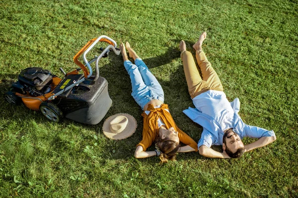 Man and woman with lawn mower on the grass — Stock Photo, Image