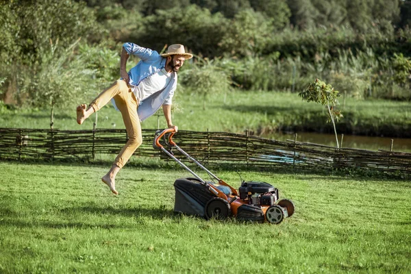 Man med gräsklippare på bakgården — Stockfoto