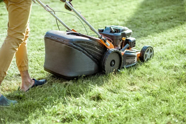 Gardener cutting grass with lawn mower — Stock Photo, Image