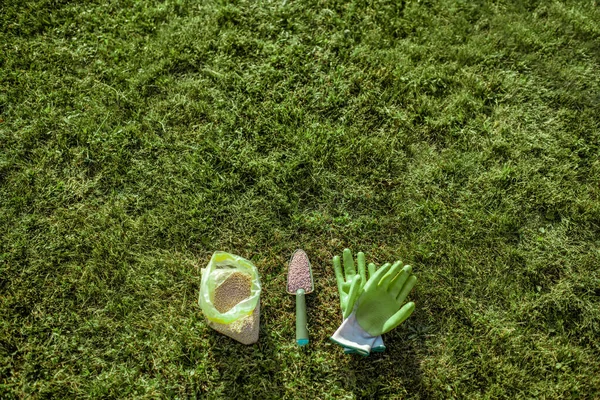Engrais et gants de travail sur l'herbe — Photo