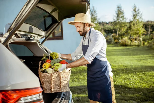 Uomo con verdure fresche vicino alla macchina in campagna — Foto Stock