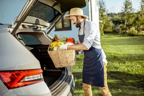 Uomo con verdure fresche vicino alla macchina in campagna — Foto Stock