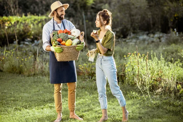 Paar met verse groenten in de tuin — Stockfoto