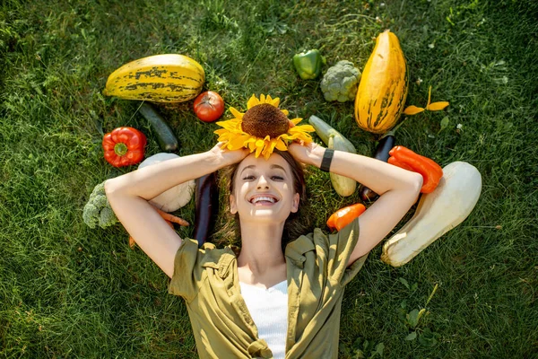 Kvinna med färska grönsaker på gräset — Stockfoto