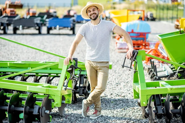 Landbouwkundige op het terrein van de winkel met landbouwmachines — Stockfoto