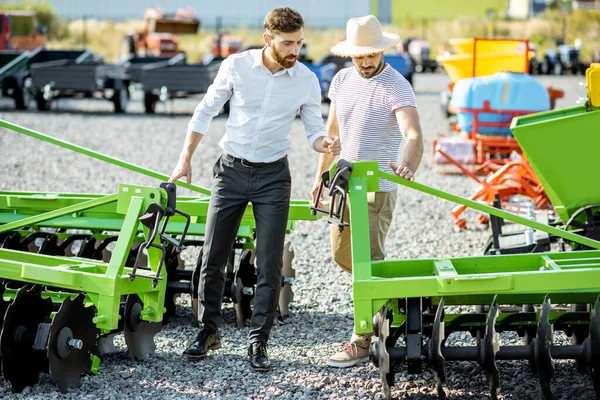 Agronom mit Verkäufer im Geschäft mit Landmaschinen — Stockfoto