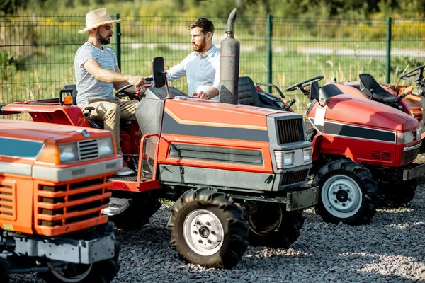 Landwirt mit Verkäufer am Traktor im Freien — Stockfoto