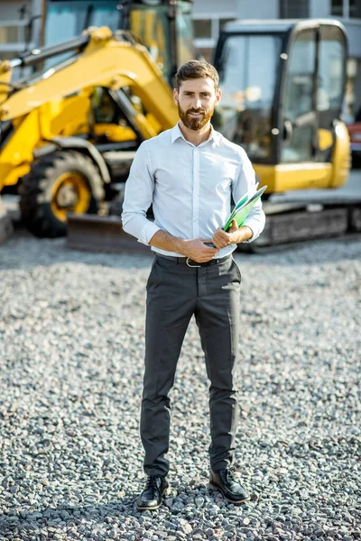 Salesman at the shop with heavy machinery — Stock Photo, Image