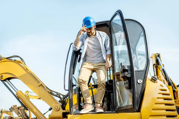 Builder near the escavator — Stock Photo, Image