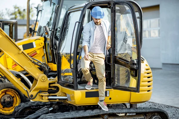 Builder near the escavator — Stock Photo, Image