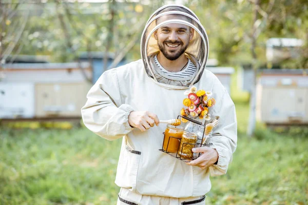 Apicoltore con miele sull'apiario — Foto Stock