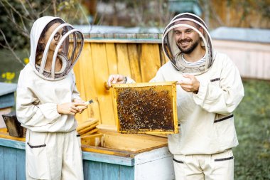 Arı yetiştiricileri arılar üzerinde çalışıyor.