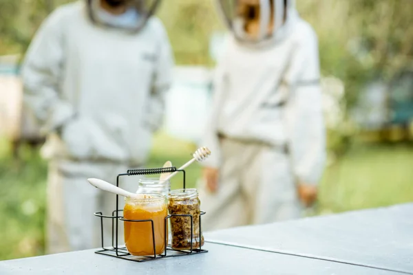 Gläser mit frischem Honig und Bienenwachs auf dem Bienenstand — Stockfoto