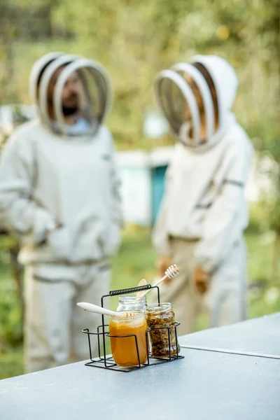 Nádoby s čerstvým medem a včelím voskem na včelíně — Stock fotografie